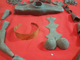 Медный топор, фибула, золотой браслет, медные кольца и лейкообразные конусы