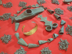 Медный топор, фибула, золотой браслет, медные кольца и лейкообразные конусы