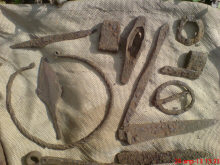 Железная шейная гривна, наконечник обоймица ножен и перекрестье сабли, обломки ножей, наконечник срелы, топорик и пряжки