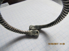 Древнерусский серебряный псевдовитой браслет с фигурными расширениями на кончиках, украшенными чернью.