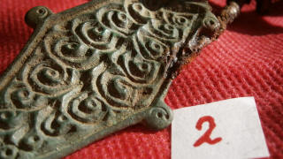 Орнамент в виде спиральных завитков на славянской пальчатой фибуле