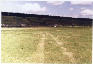 Вид на городище с востока из поймы. Стрелками показан эскарп.